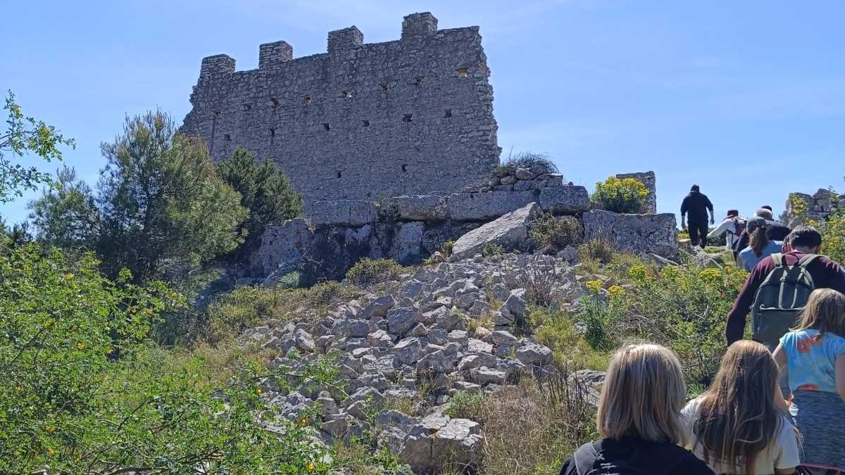 Grupa ljudi pješaći prema ostacima vojne utvrda Gradina na otoku Žirju